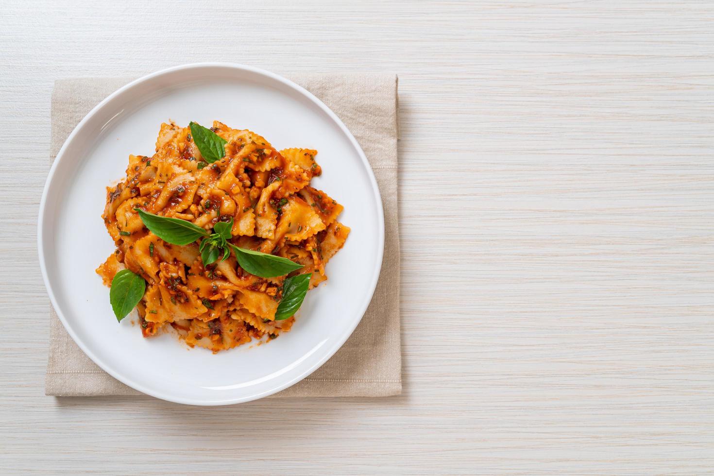 Farfalle pasta with basil and garlic in tomato sauce - Italian sauce photo