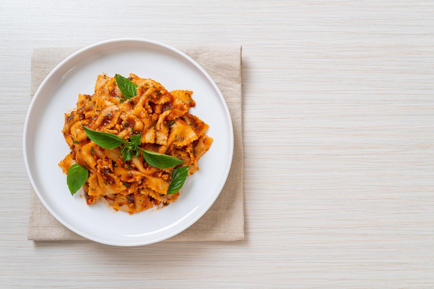 pasta farfalle con albahaca y ajo en salsa de tomate - salsa italiana foto