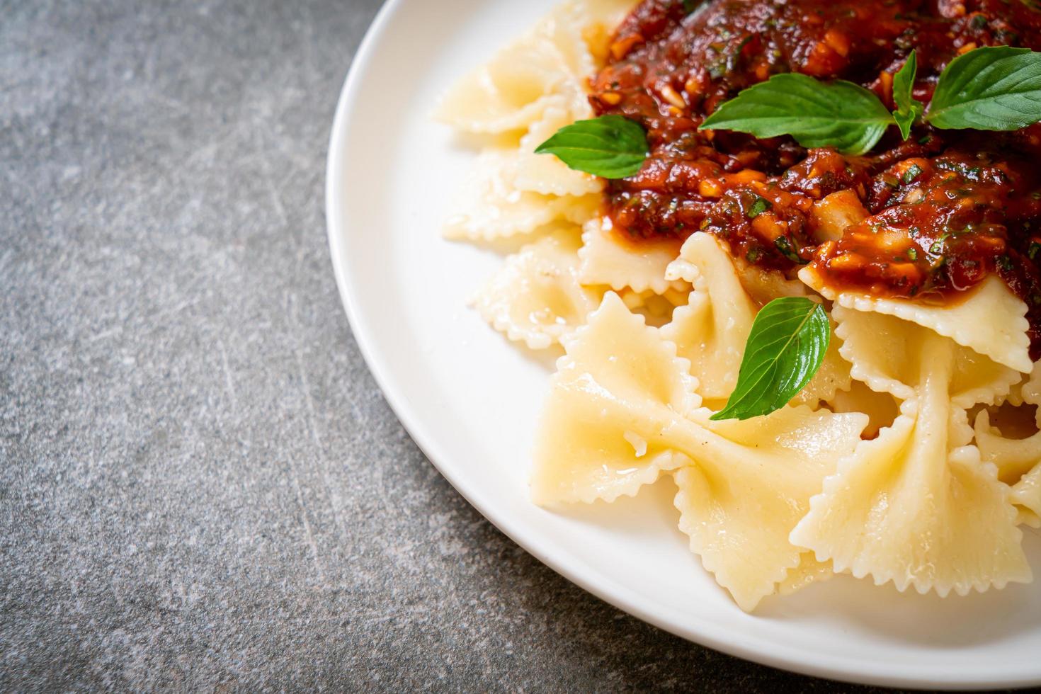 Farfalle pasta with basil and garlic in tomato sauce - Italian sauce photo