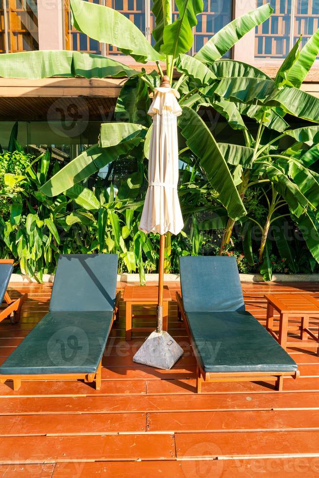 Empty pool bed around swimming pool with umbrellas and sunlight photo