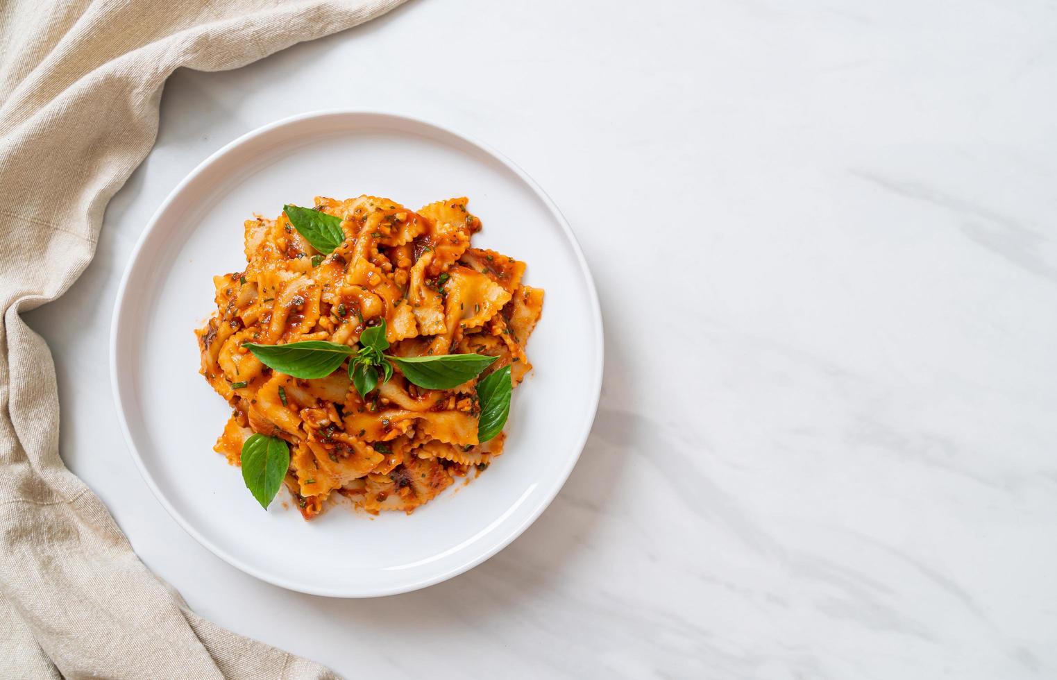 Farfalle pasta with basil and garlic in tomato sauce - Italian sauce photo