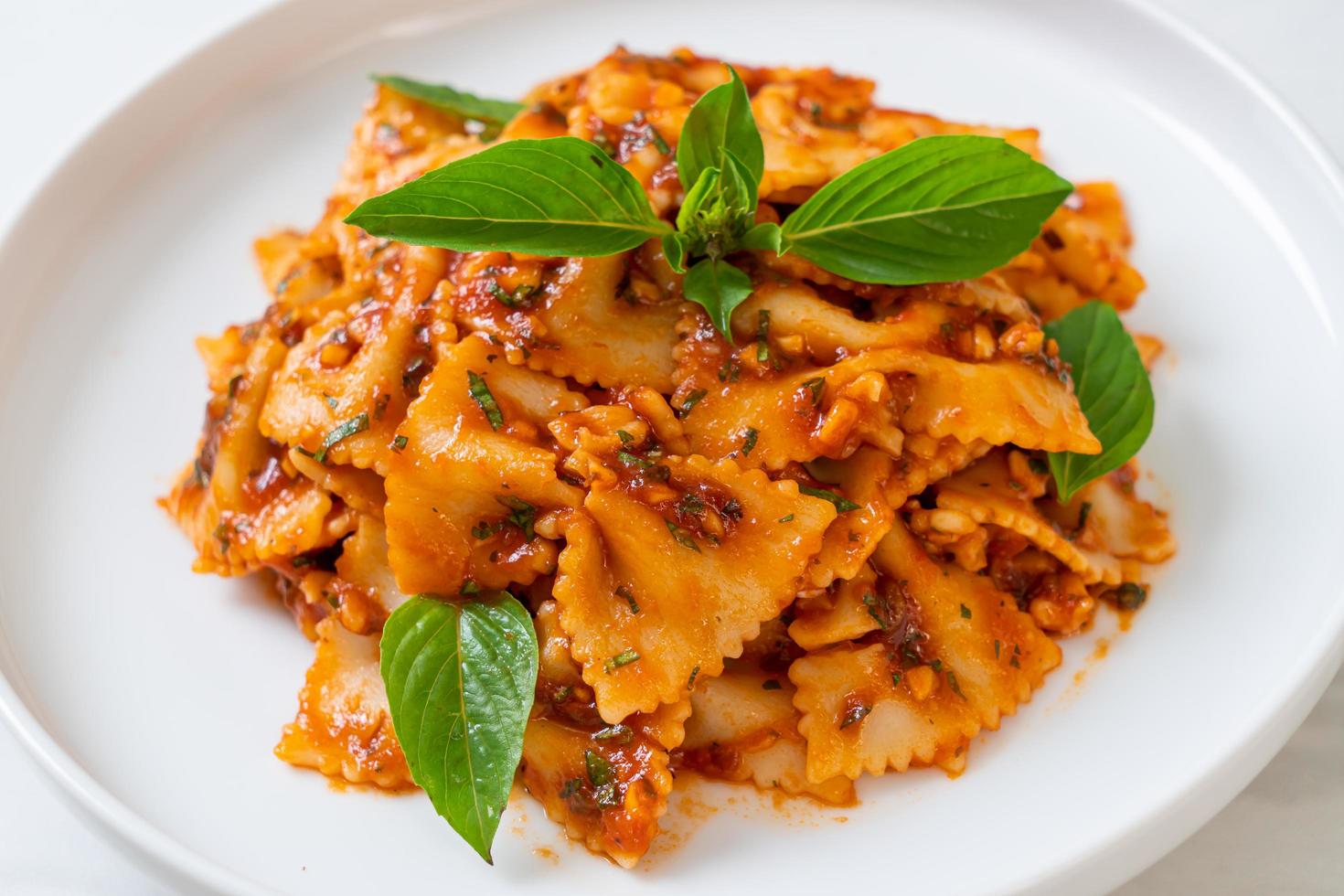 Farfalle pasta with basil and garlic in tomato sauce - Italian sauce photo