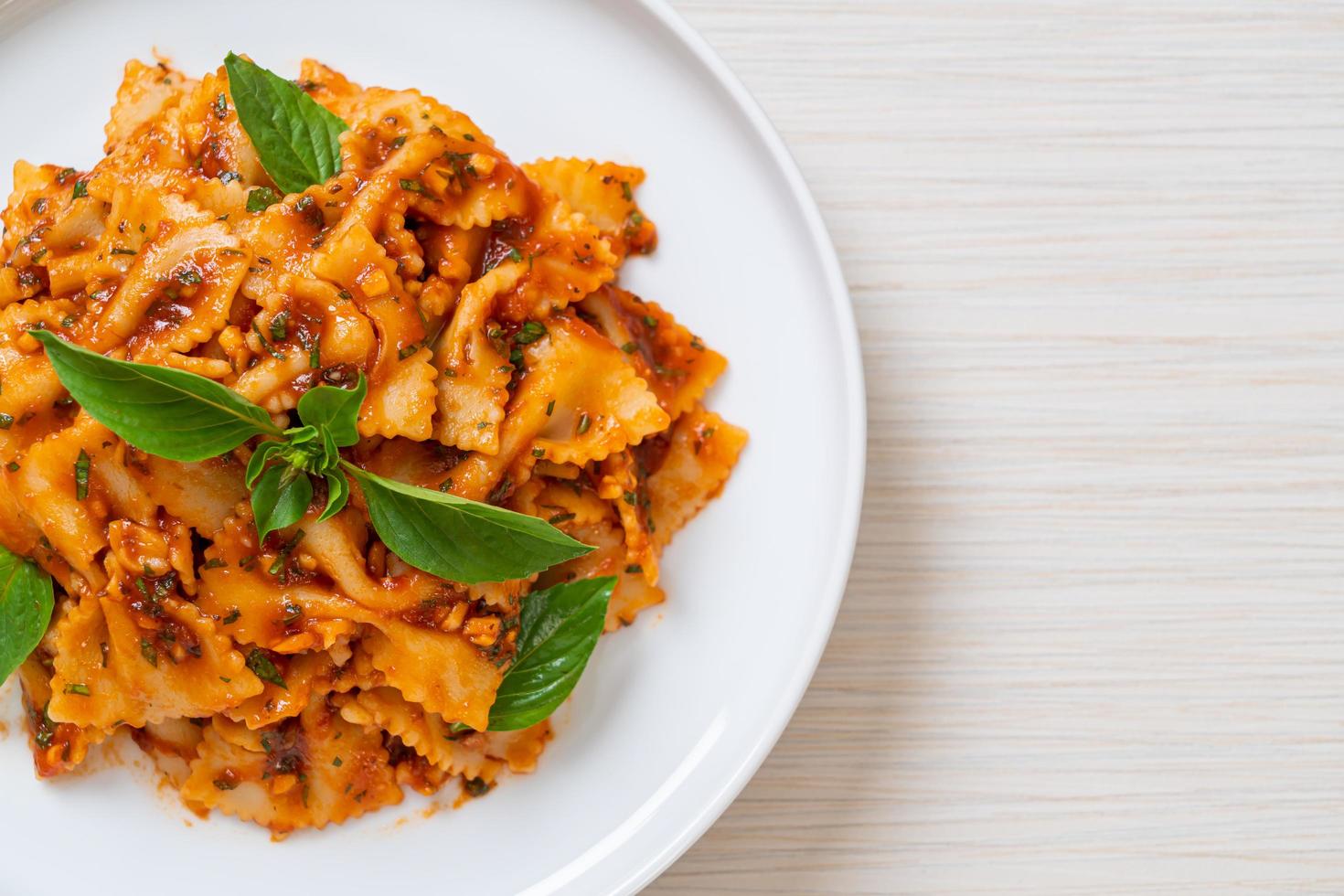 Farfalle pasta with basil and garlic in tomato sauce - Italian sauce photo