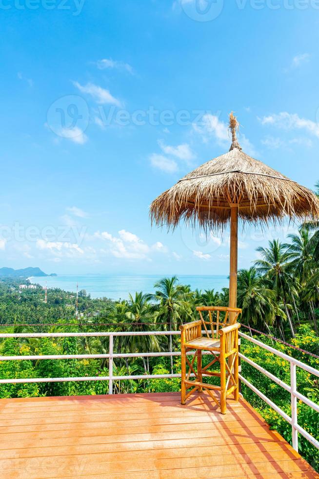 Silla vacía en el balcón con el fondo del mirador del mar océano en Tailandia foto