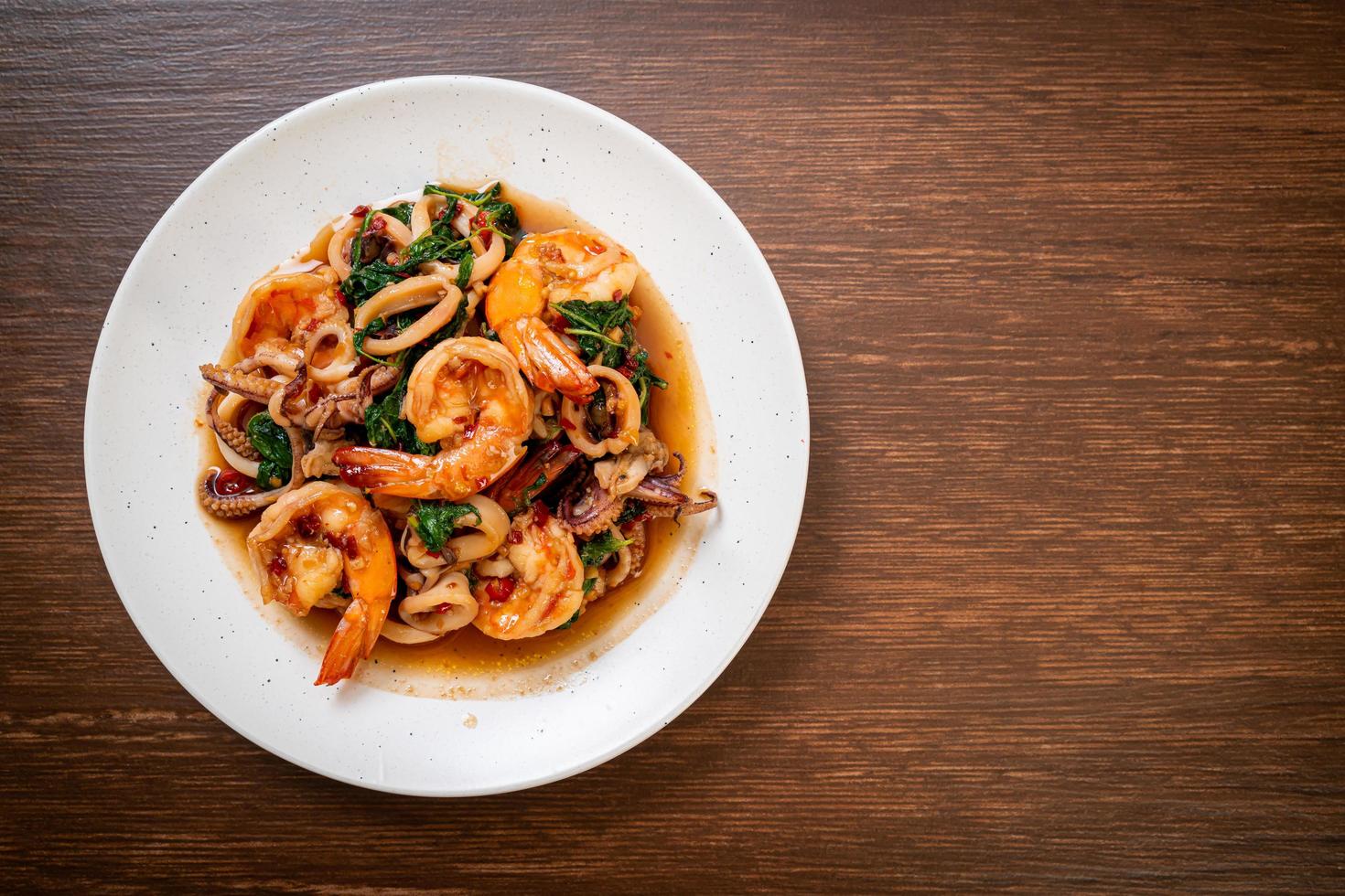 mariscos salteados de camarones y calamares con albahaca tailandesa - estilo de comida asiática foto