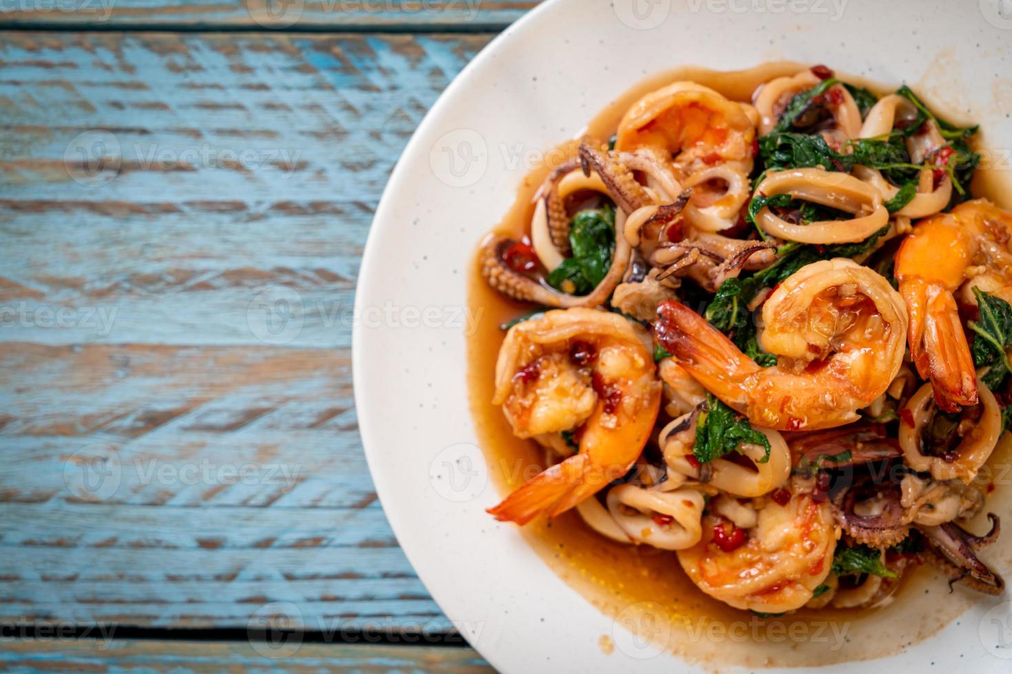 Stir-fried seafood of shrimp and squid with Thai basil - Asian food style photo