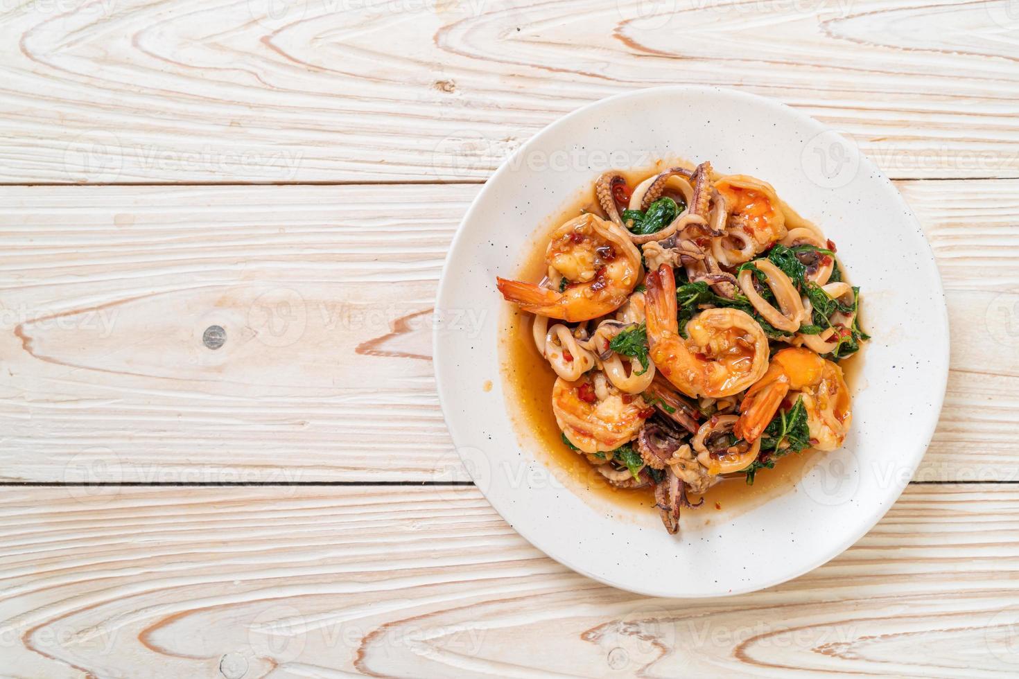 mariscos salteados de camarones y calamares con albahaca tailandesa - estilo de comida asiática foto