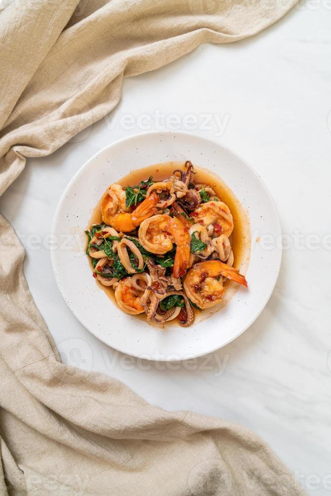 Stir-fried seafood of shrimp and squid with Thai basil - Asian food style photo