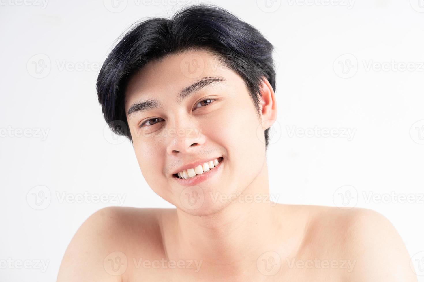 Joven apuesto hombre asiático sobre fondo blanco. foto