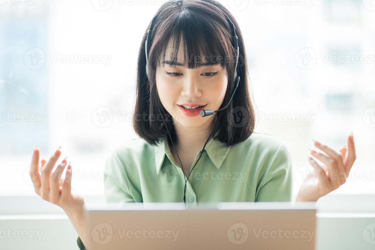 Beautiful Asian customer service lady is calling customers to offer products photo