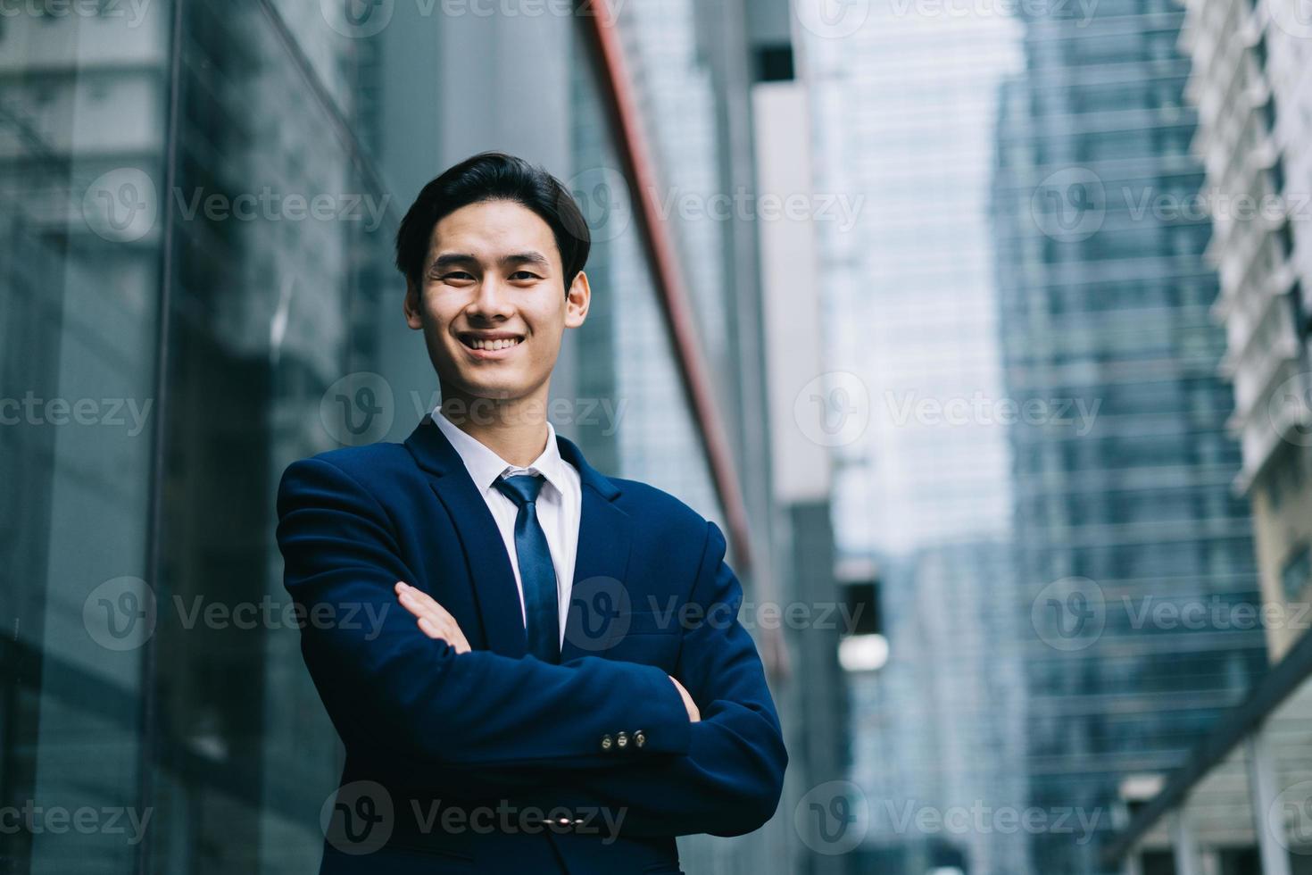 Young Asian businessman with modern building background photo