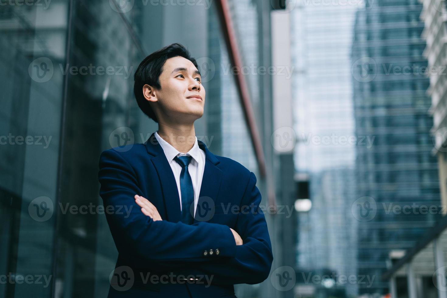 joven empresario asiático con fondo de edificio moderno foto