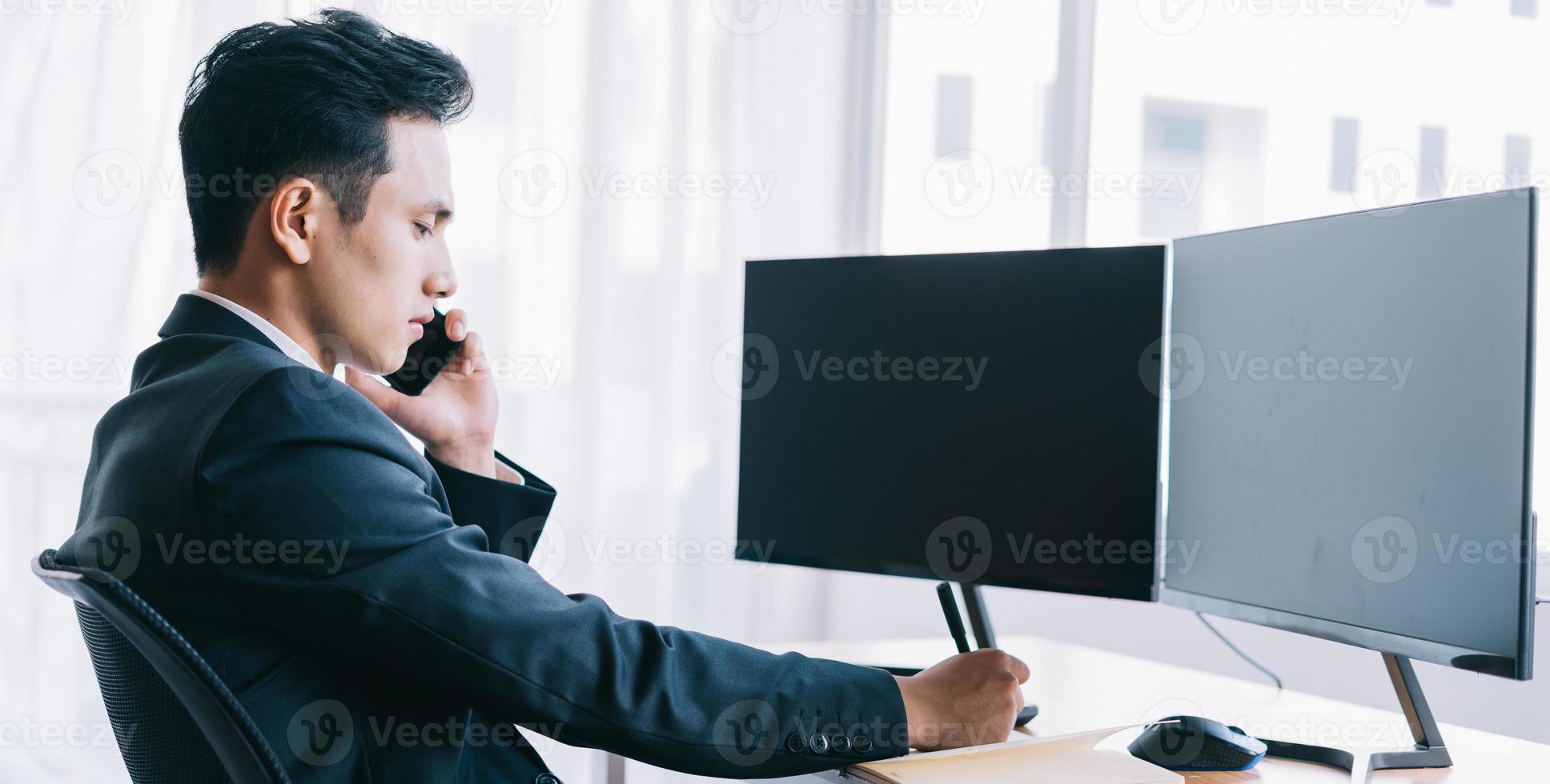 Asian businessman focused on working while on the phone photo