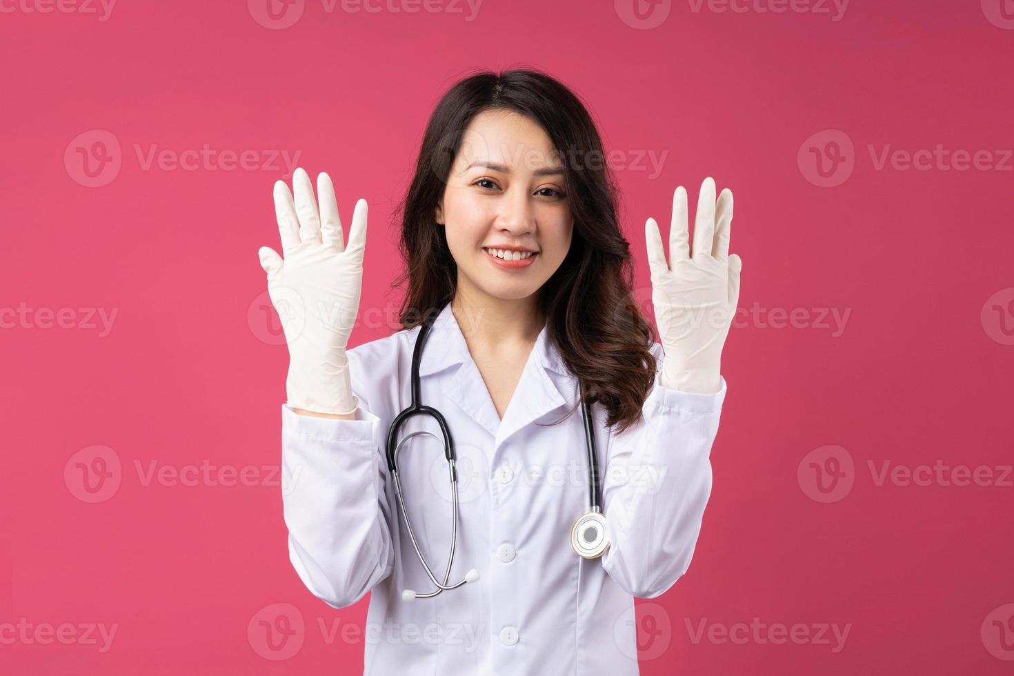 Young Asian female doctor with cheerful expression on background photo