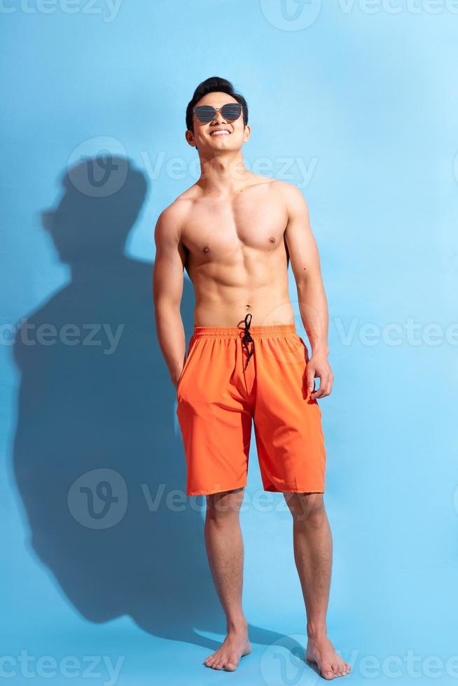 Handsome Asian man on blue background photo