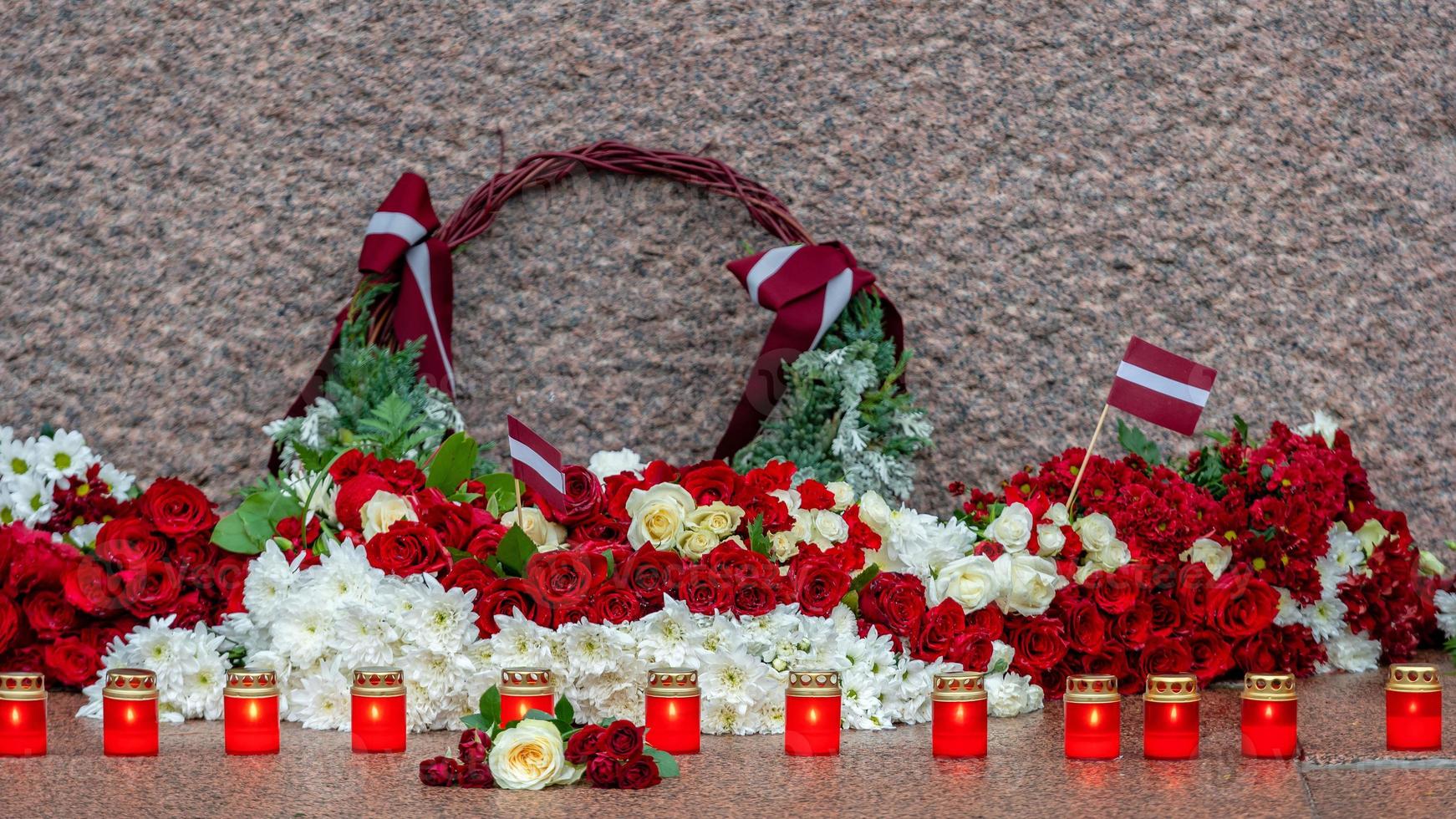 Latvia 100 years. Red and white flowers compositions at the Freedom Monument in city Riga, Latvia photo