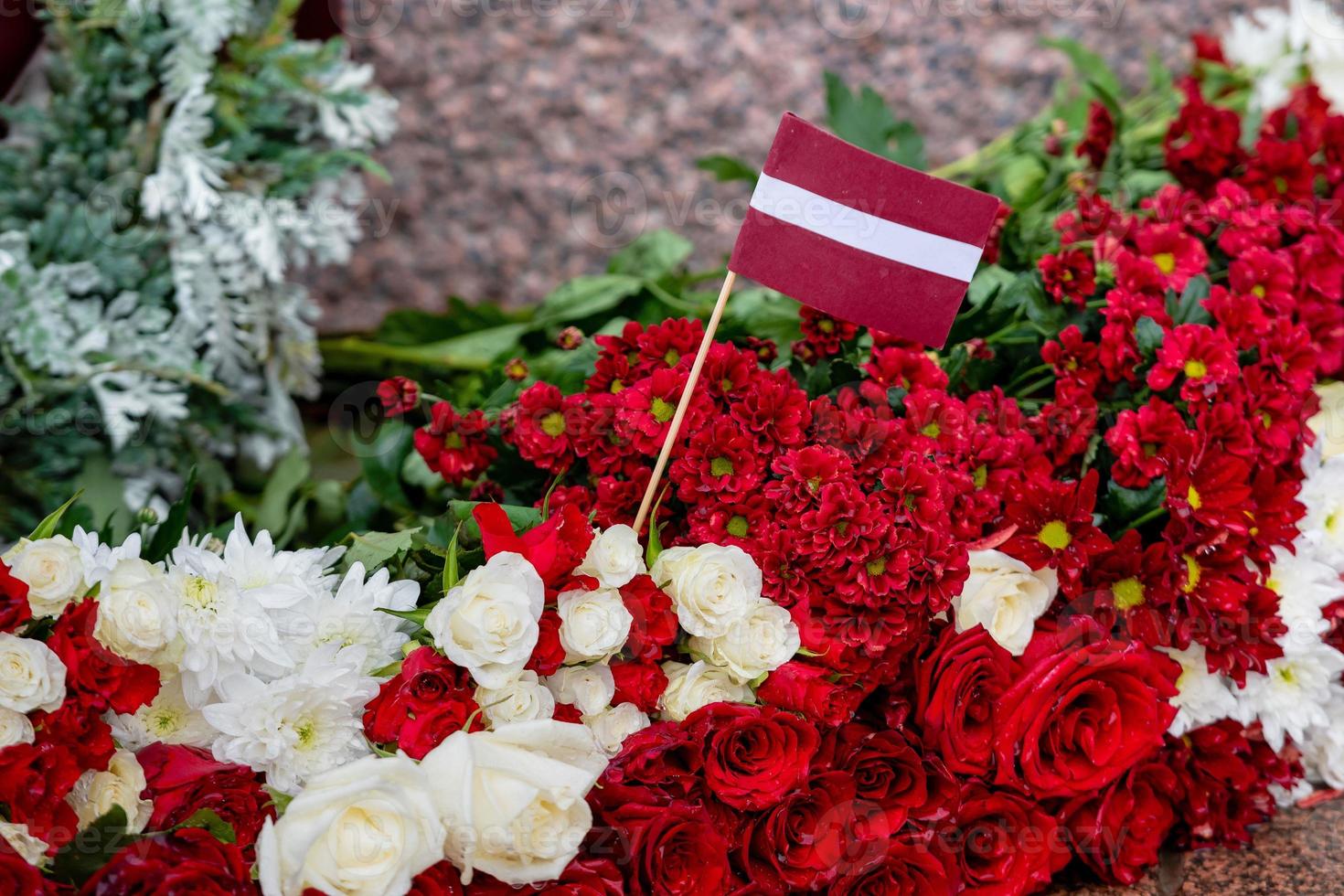 Latvia 100 years. Red and white flowers compositions at the Freedom Monument in city Riga, Latvia photo