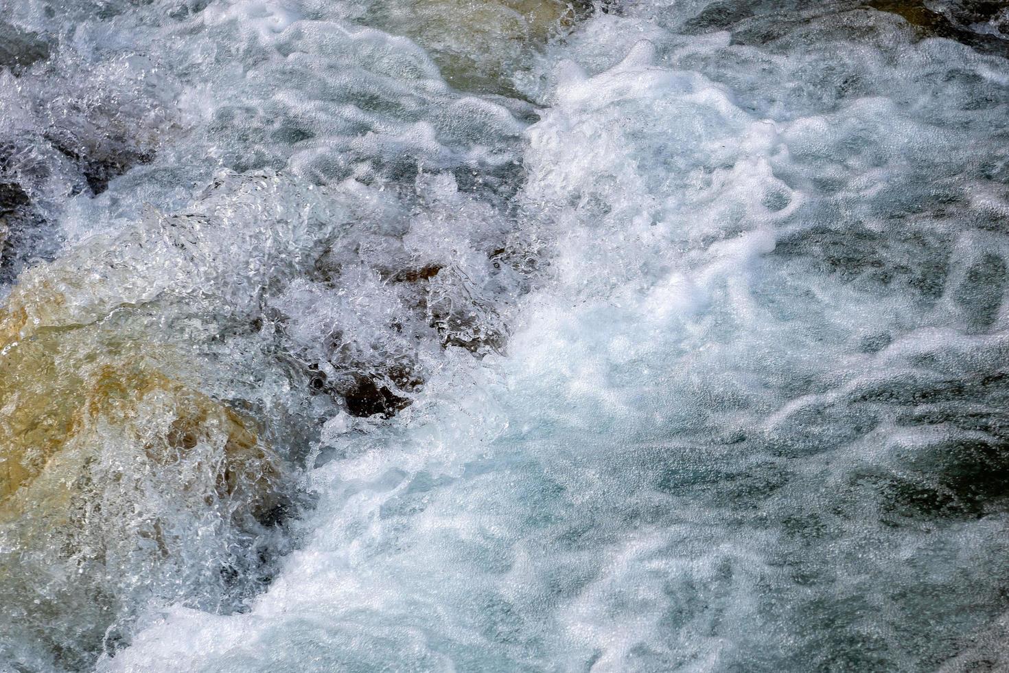 poderoso flujo de agua sobre las piedras, río de montaña de cerca. foto