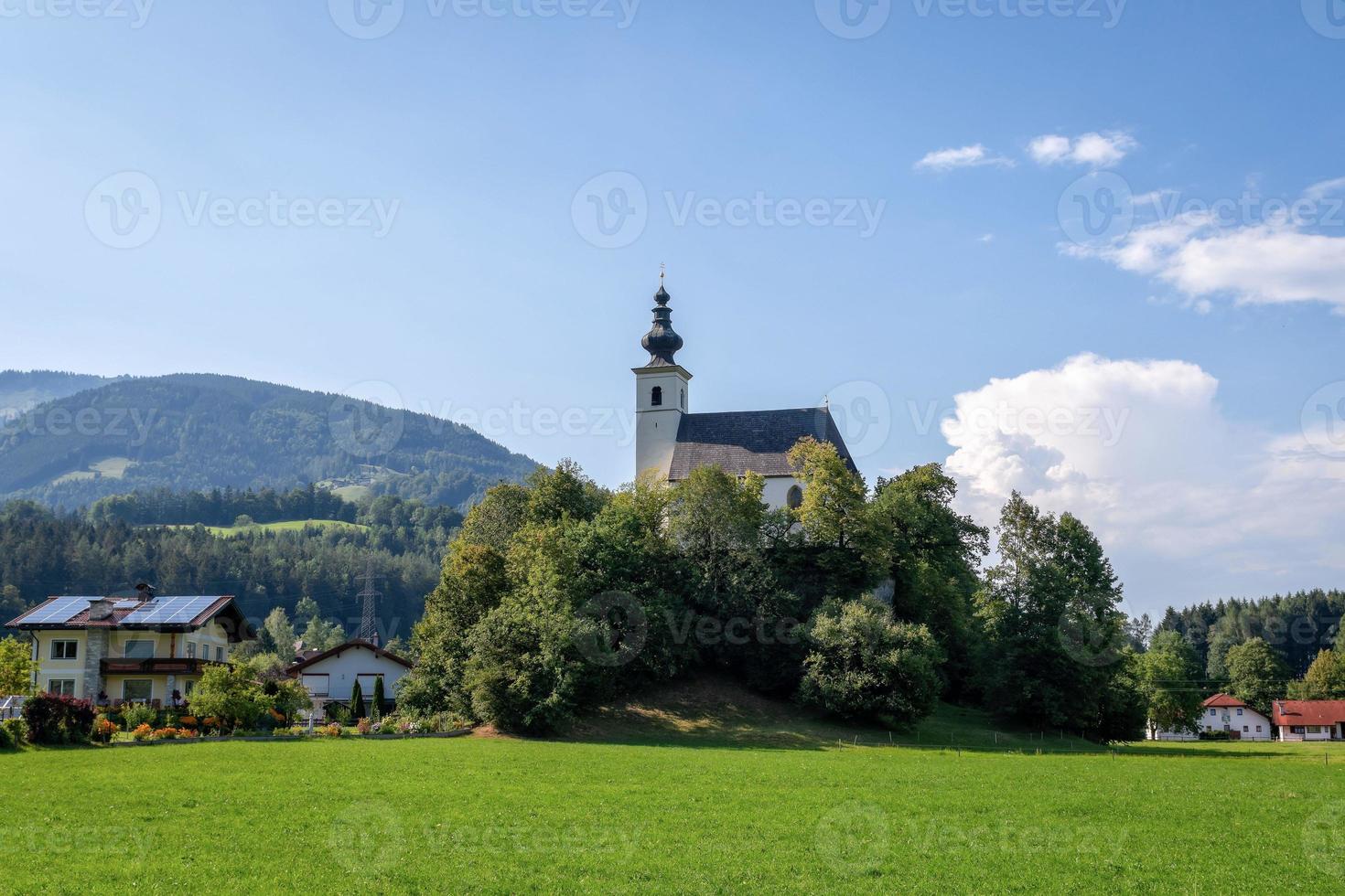 pueblo con una iglesia en el valle alpino cerca de salzburgo. Austria foto