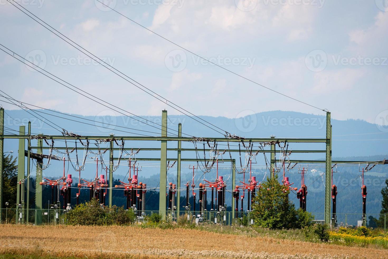 High-voltage substation on mountains and blue sky background. photo