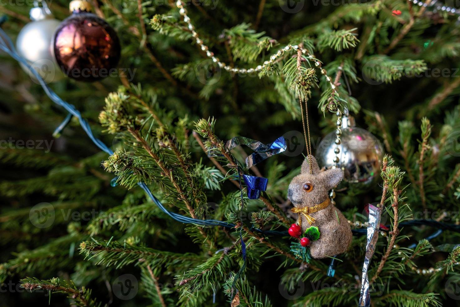 varios adornos navideños de colores colgados de ramas de abeto. foto