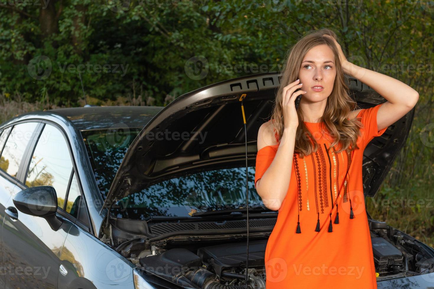 Mujer joven cerca de coche roto hablando por teléfono necesita ayuda - imagen foto