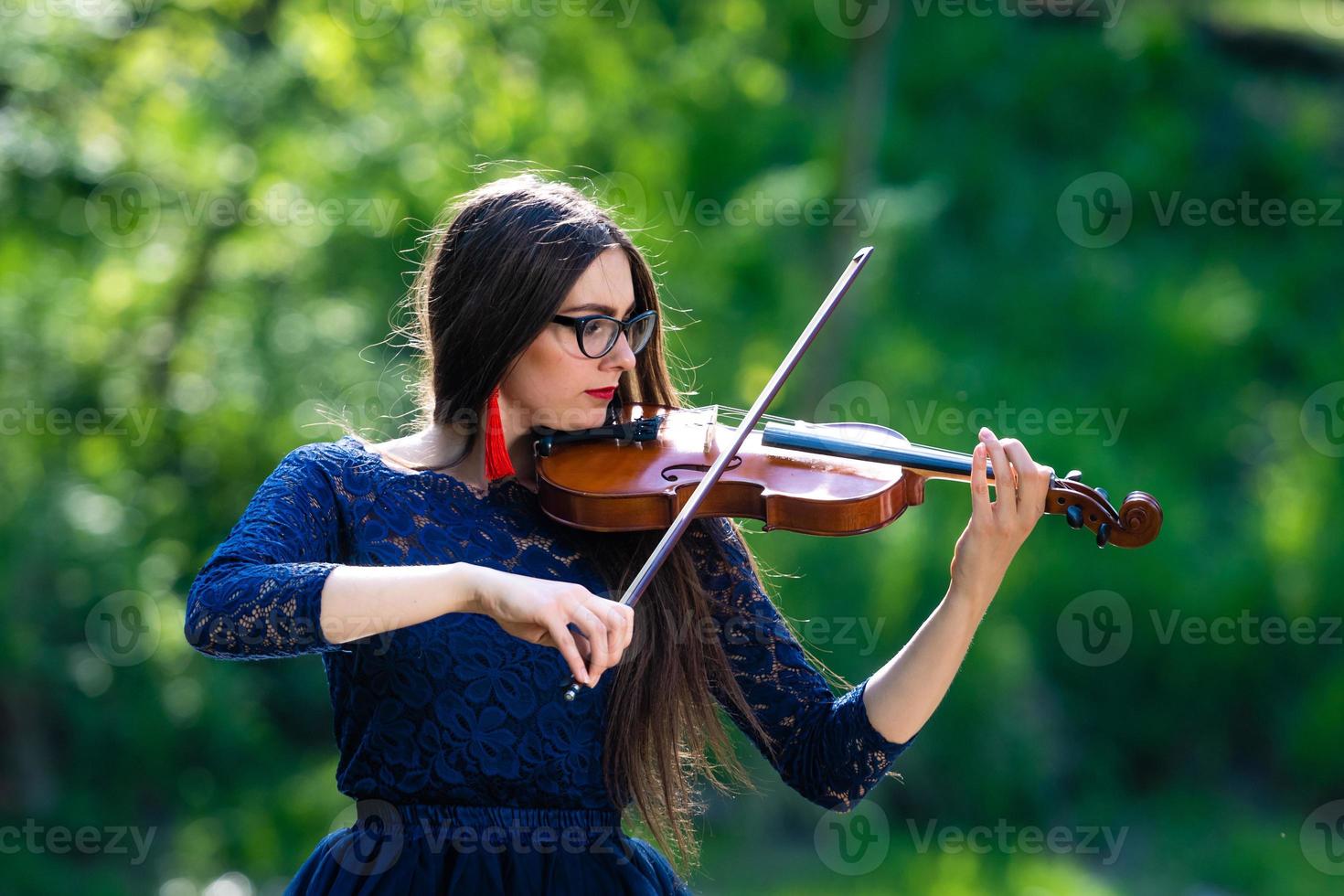 mujer joven tocando el violín en el parque. poca profundidad de campo - imagen foto