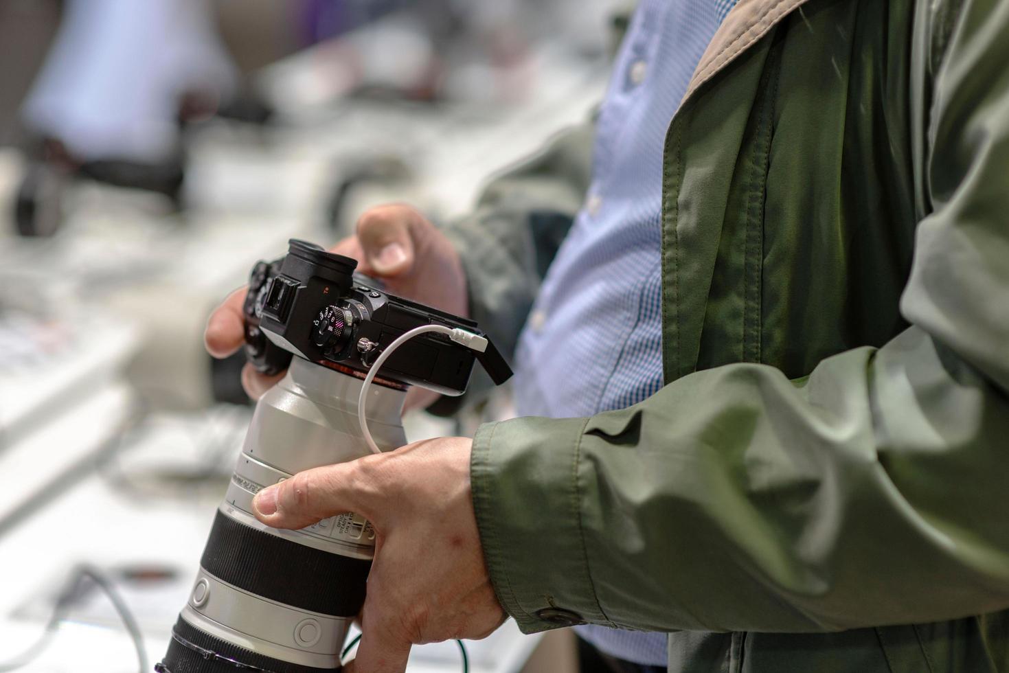 A man in a shop is trying out a new photo camera.