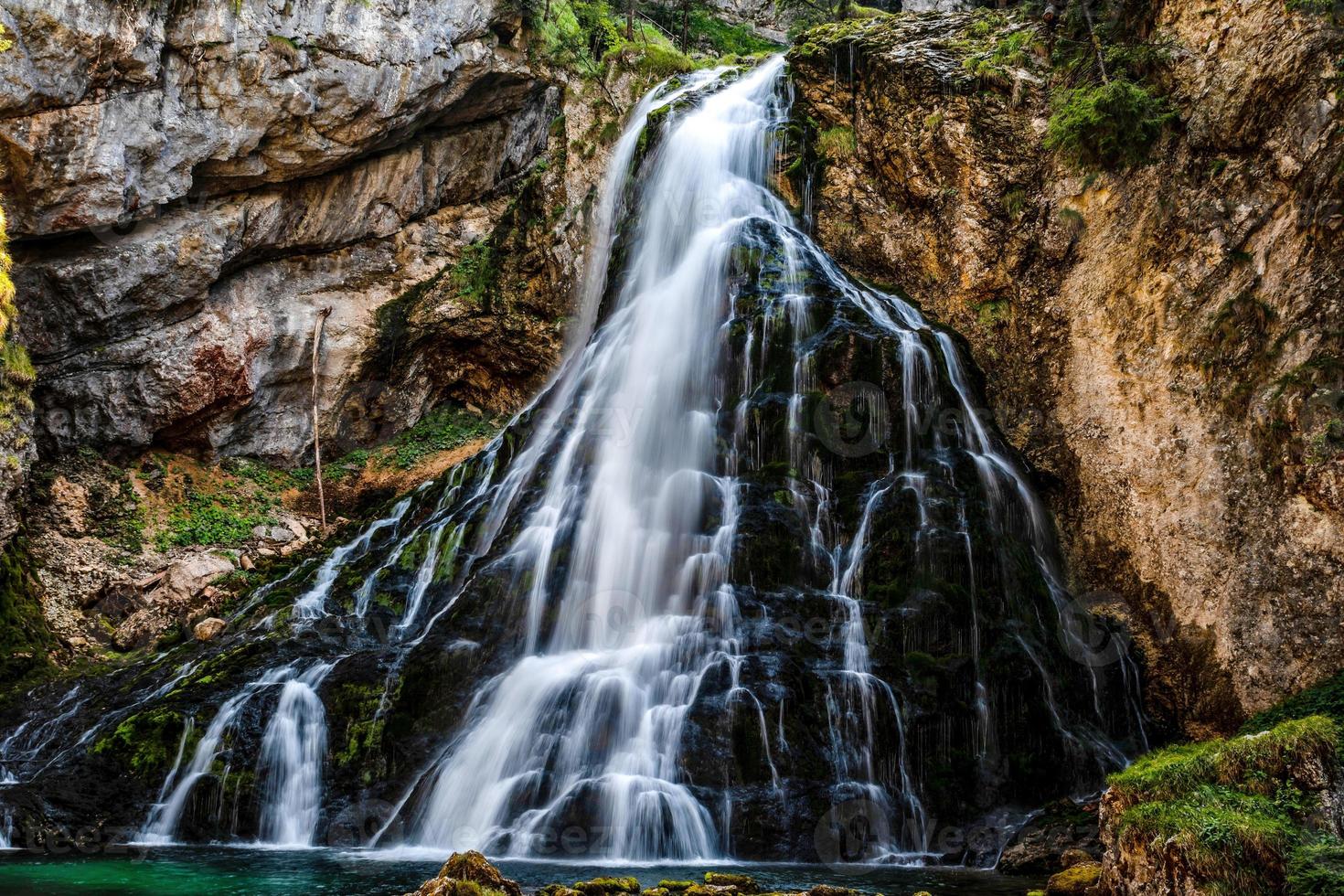 Hermosa vista del famoso gollinger wasserfall con rocas cubiertas de musgo y árboles verdes, golling, salzburger land, austria foto