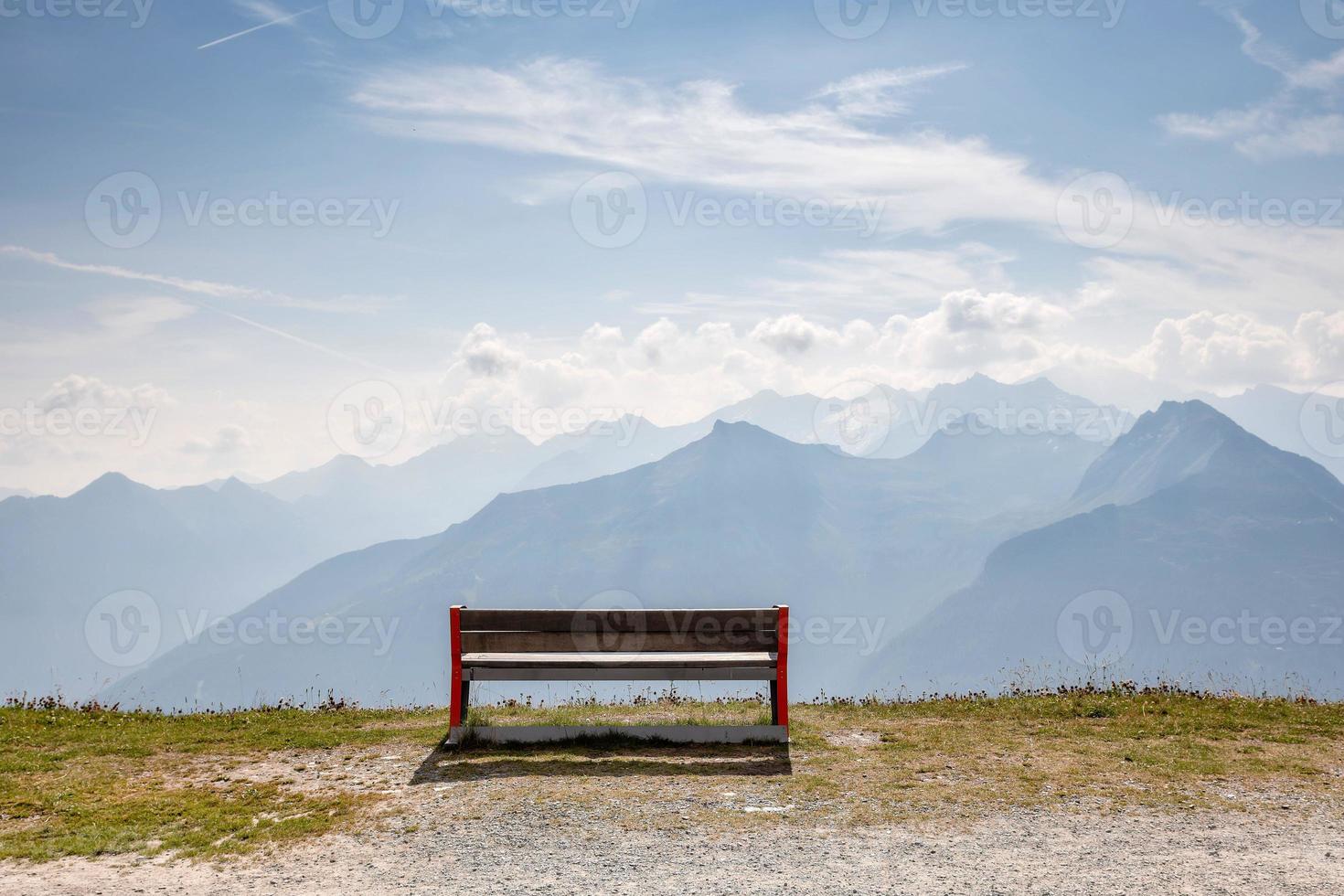 A wooden bench at the top of the Alps photo