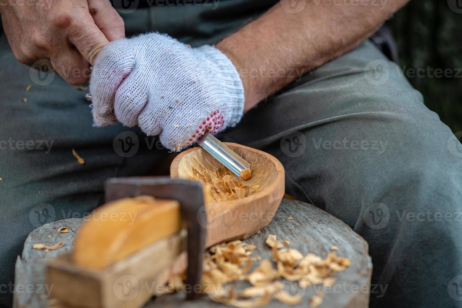 artesano demuestra el proceso de fabricación de cucharas de madera foto