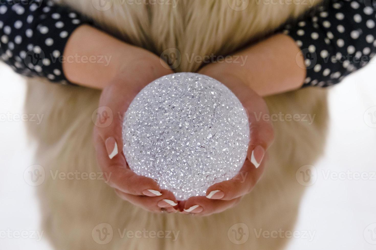 manos de mujer con una decoración navideña brillante foto