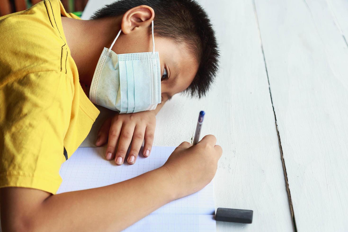 concepto de educación, escuela y pandemia - niño estudiante con máscara médica protectora facial para protegerse de enfermedades virales foto