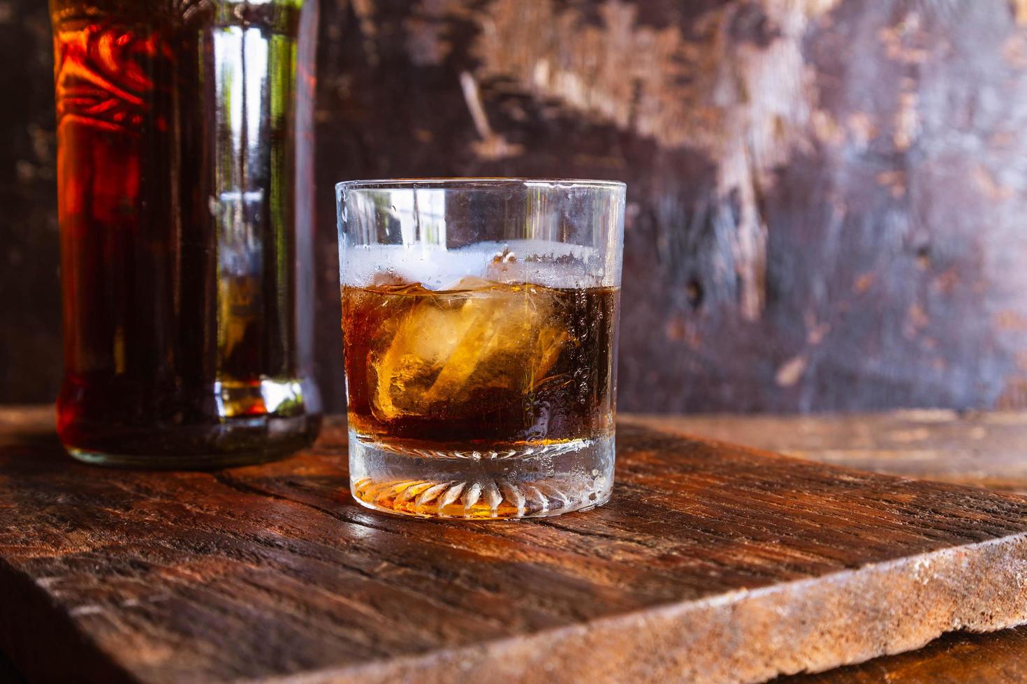 Vaso de licor y decantador de mesa de madera foto