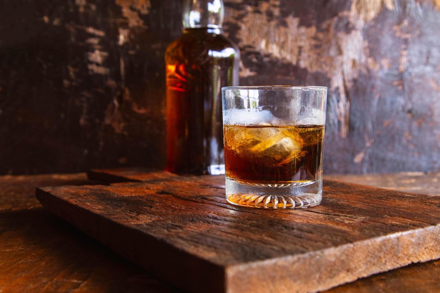 Liquor glass and decanter on wooden table photo