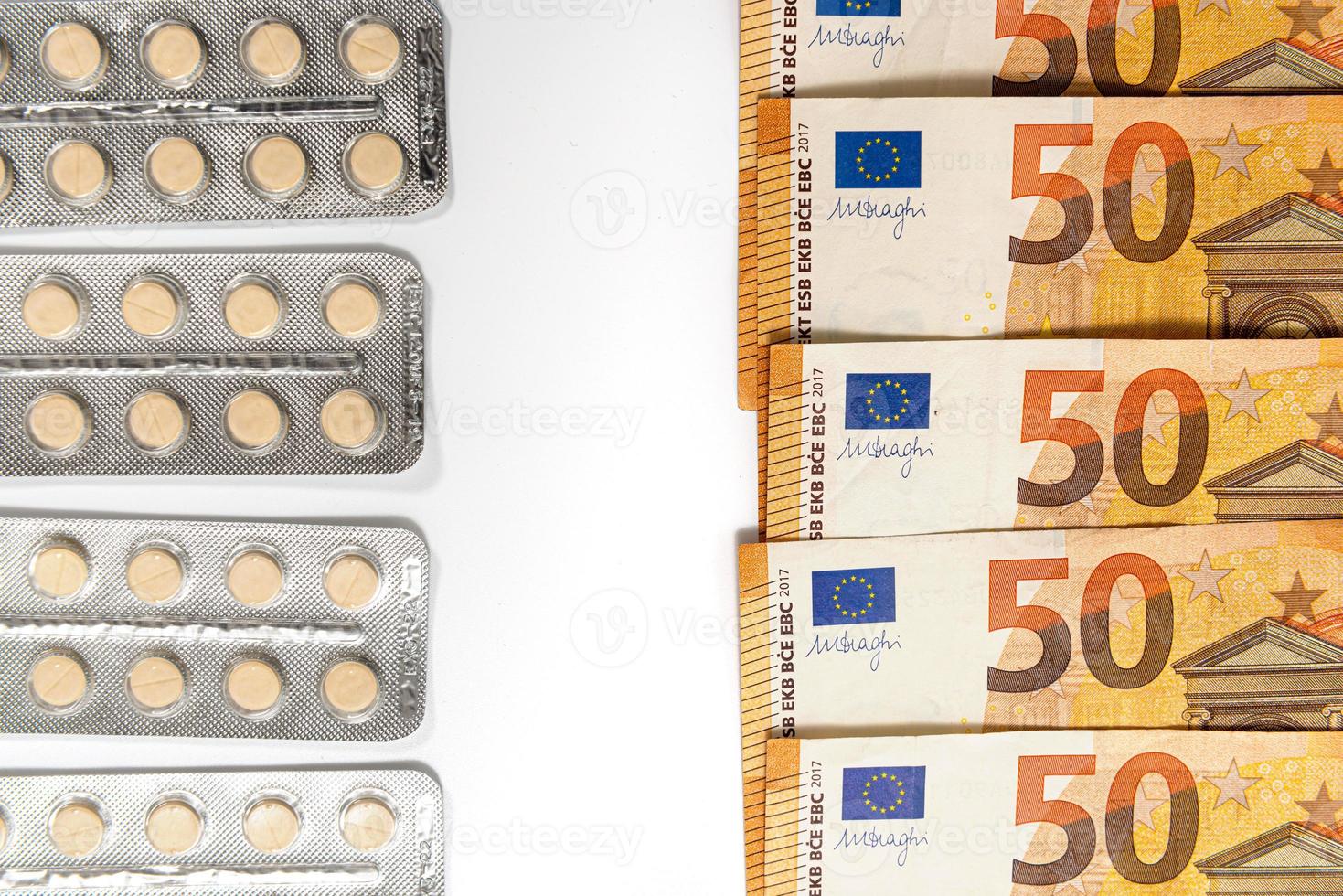 Medicamentos y billetes de euro aislados en blanco foto
