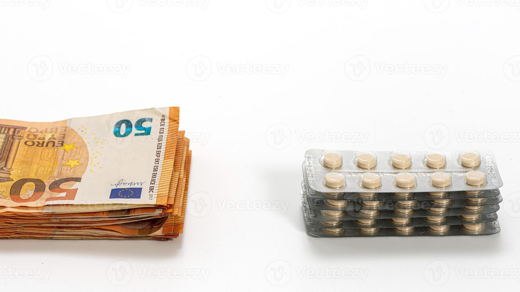 Medicamentos y billetes de euro aislados en blanco foto