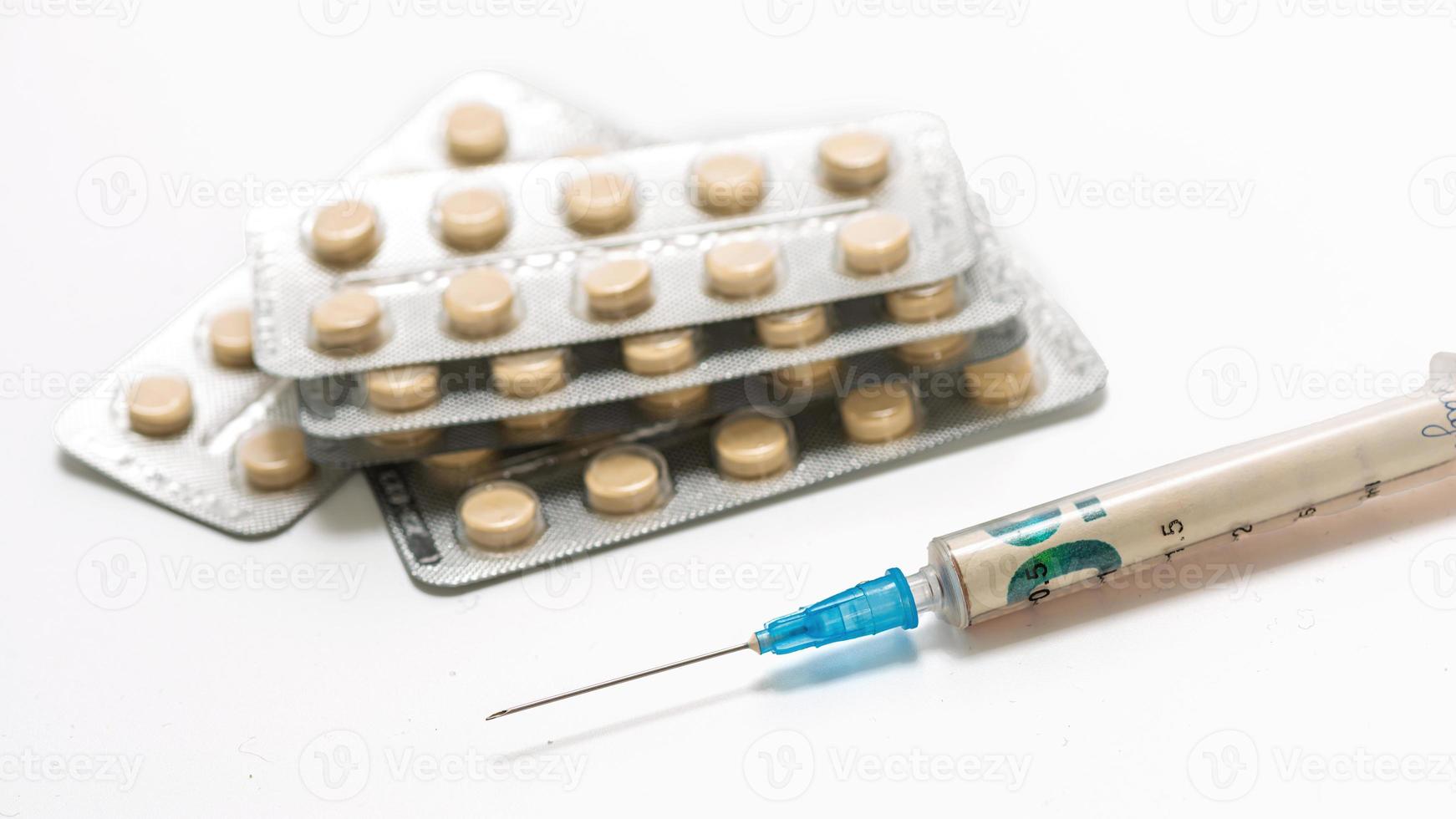 Medical syringe and pills isolated on white background photo
