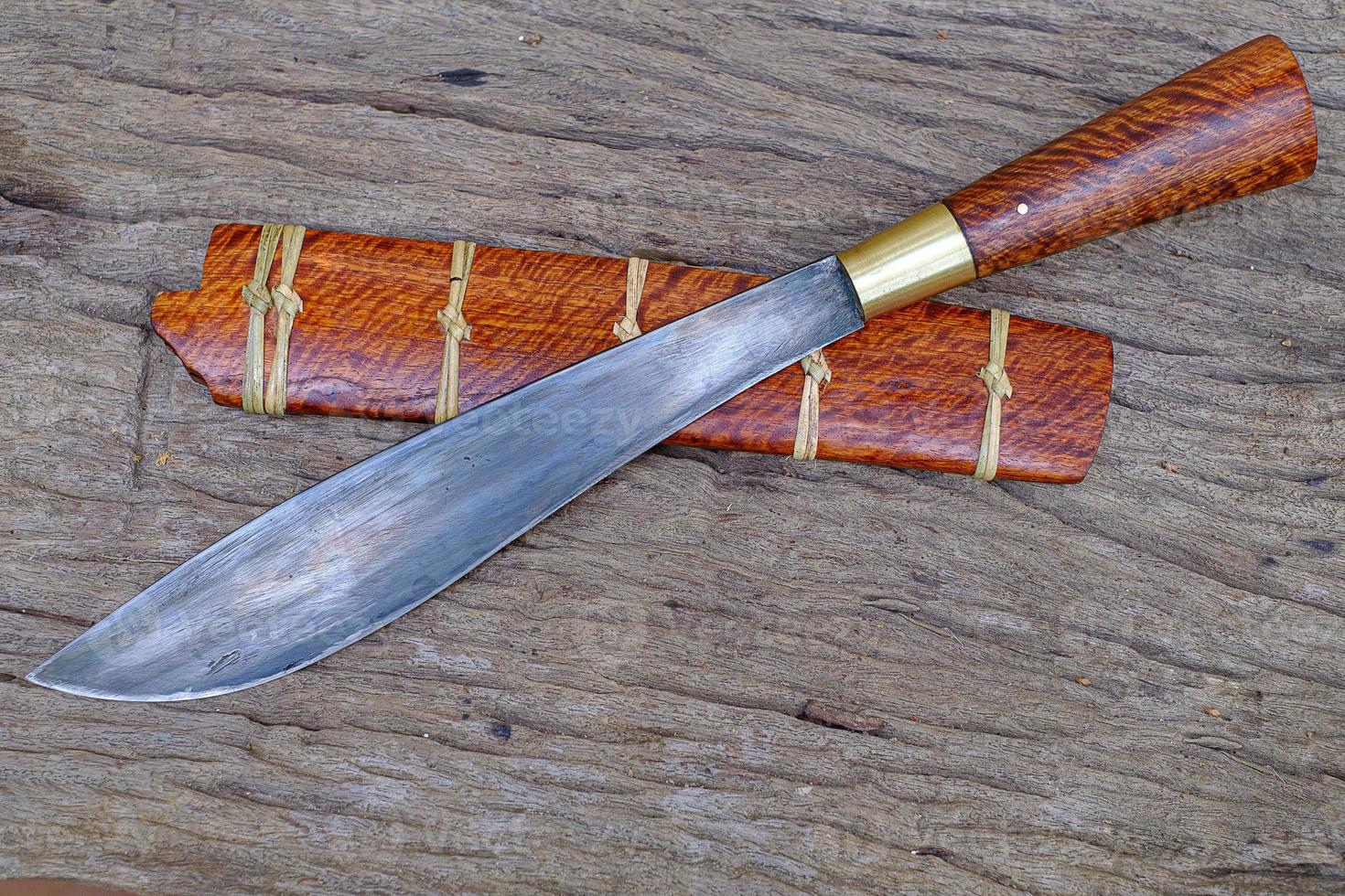 Cuchillo personalizado o enep en la vaina de madera natural sobre fondo de mesa antiguo hecho a mano de Tailandia foto