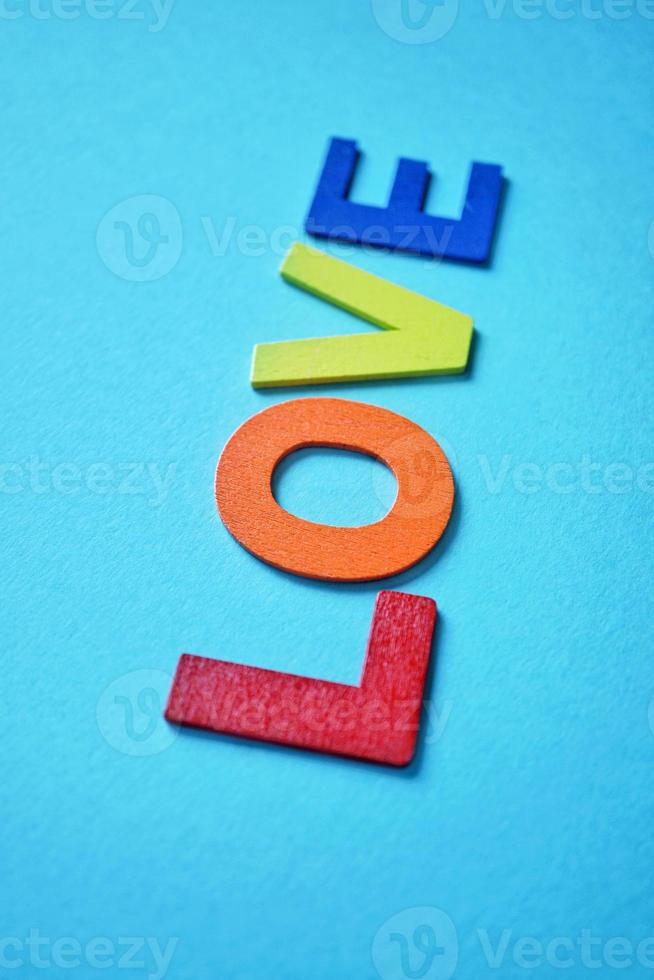 love word with wooden letters on the blue background for valentine's day photo