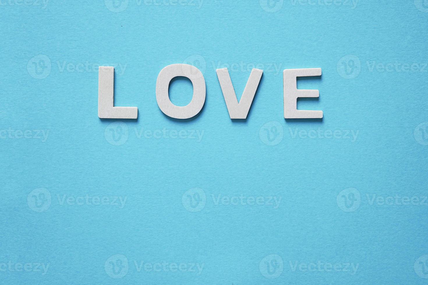 love word with wooden letters on the blue background for valentine's day photo