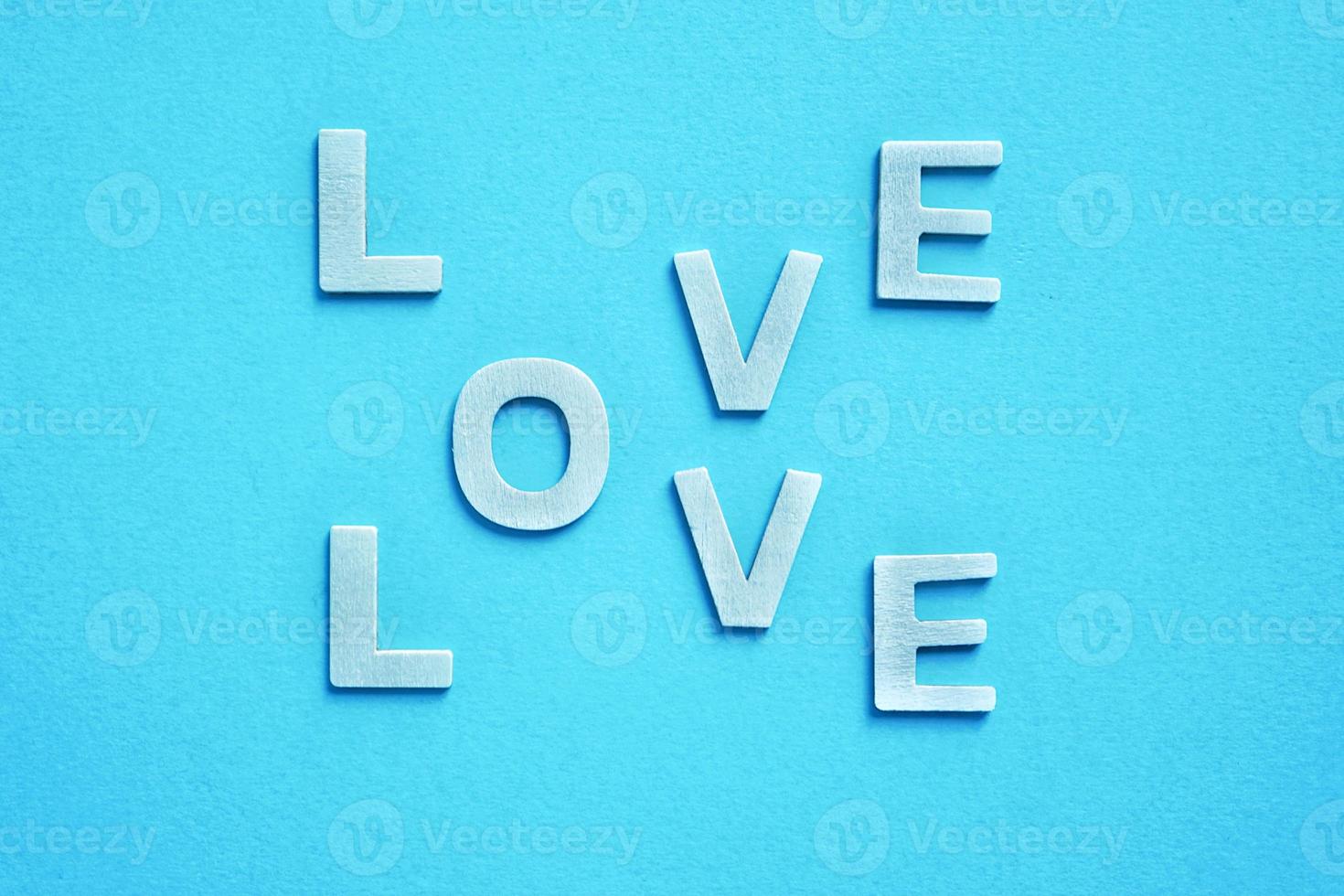 Palabra de amor con letras de madera sobre fondo azul para el día de San Valentín foto