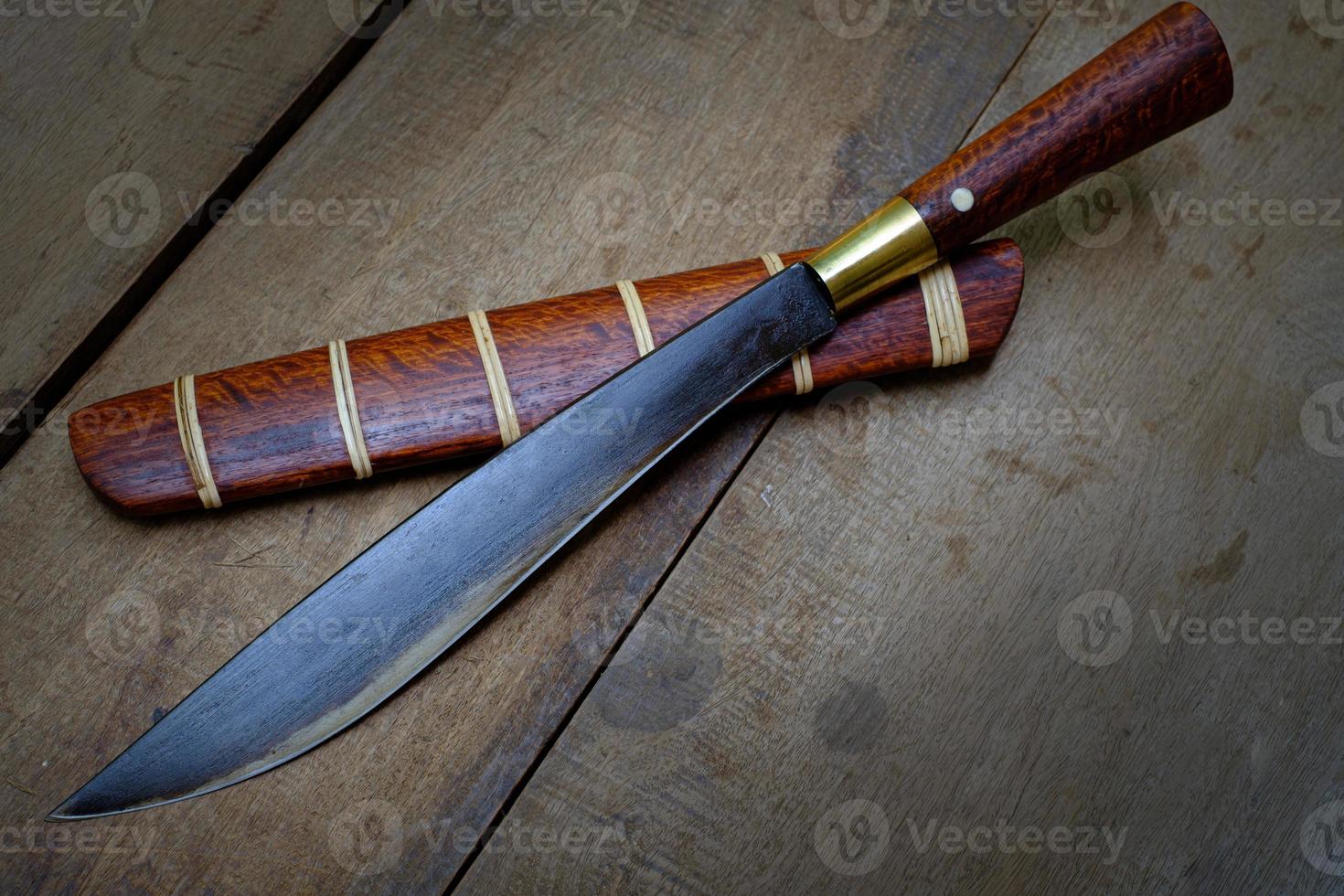 Cuchillo personalizado o enep en la vaina de madera natural sobre fondo de mesa antiguo hecho a mano de Tailandia foto