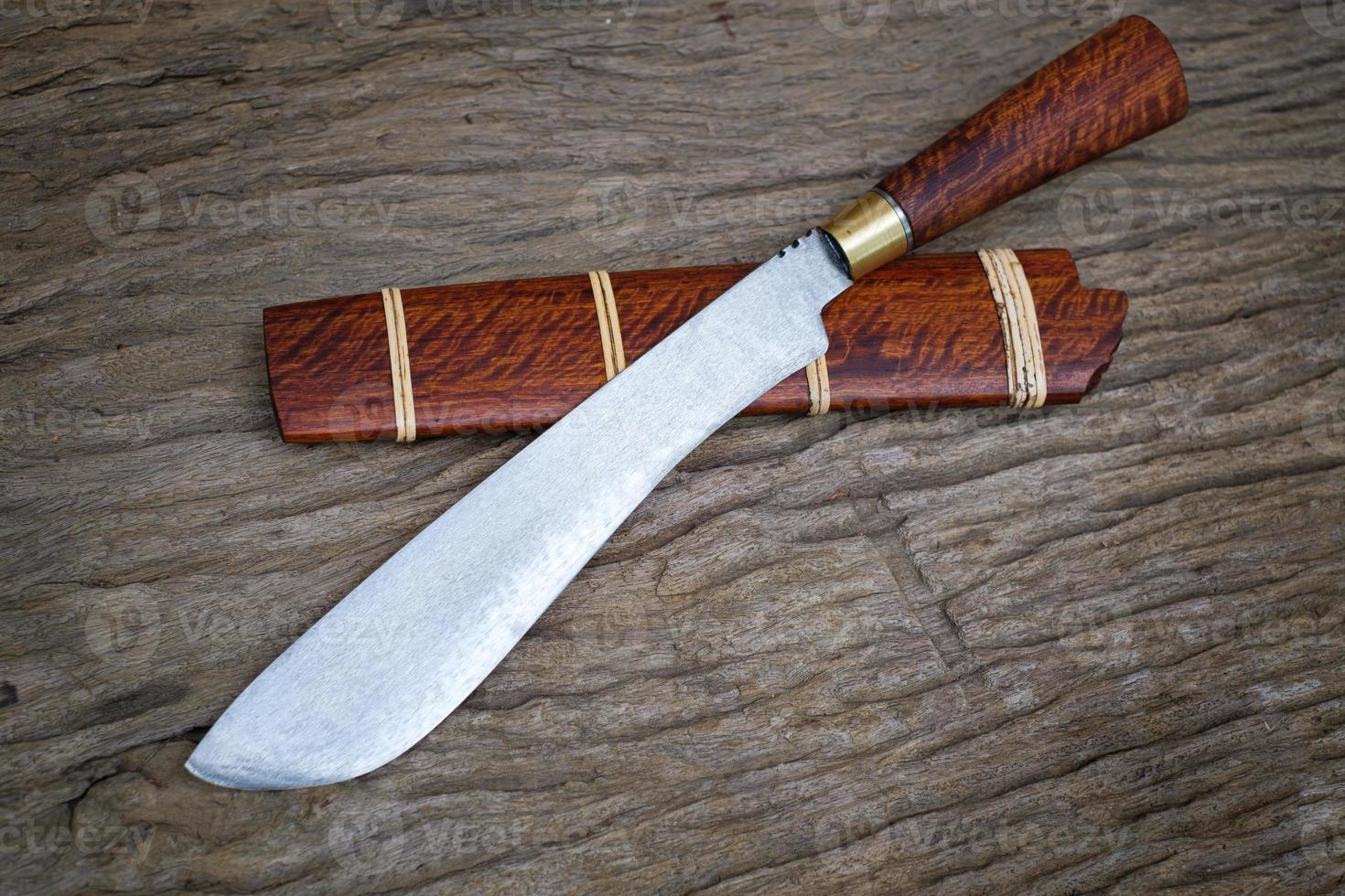 Cuchillo personalizado o enep en la vaina de madera natural sobre fondo de mesa antiguo hecho a mano de Tailandia foto