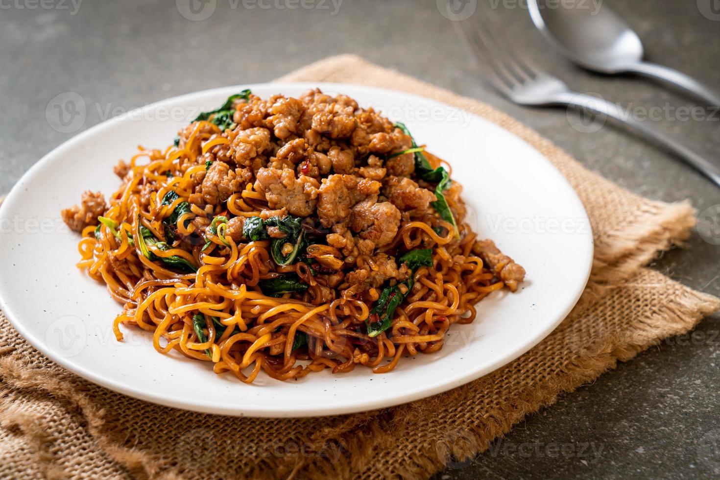 fideos instantáneos salteados con albahaca tailandesa y carne de cerdo picada - estilo de comida asiática foto