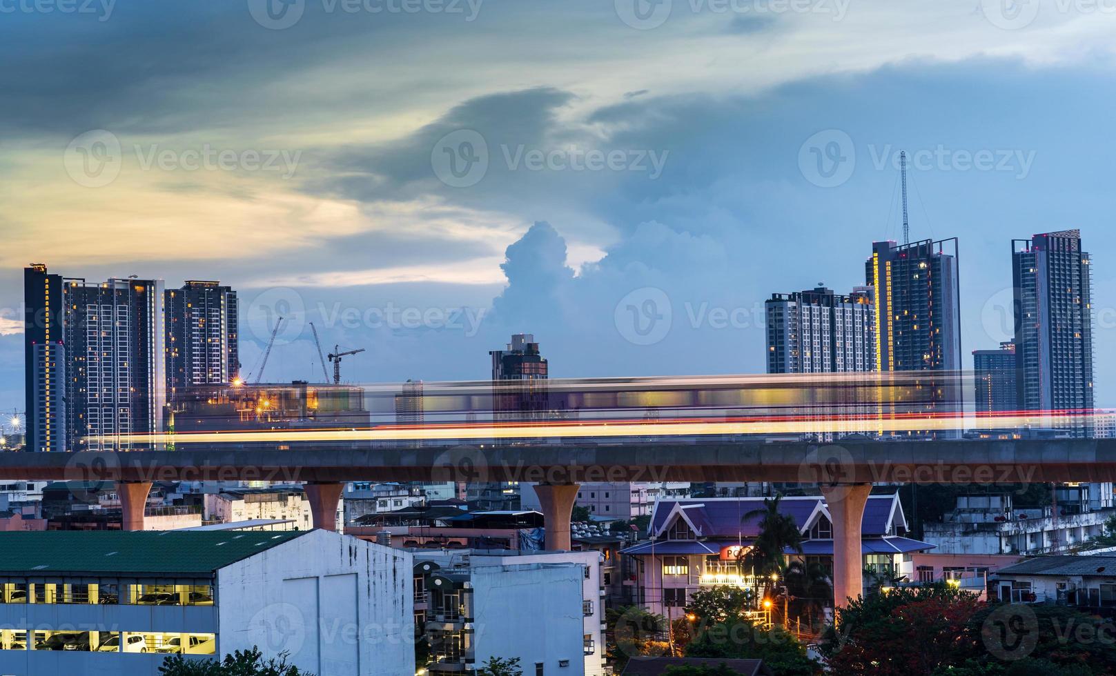 Light line of the Skytrain in city downtown with blue sky and clouds at Bangkok, Thailand photo