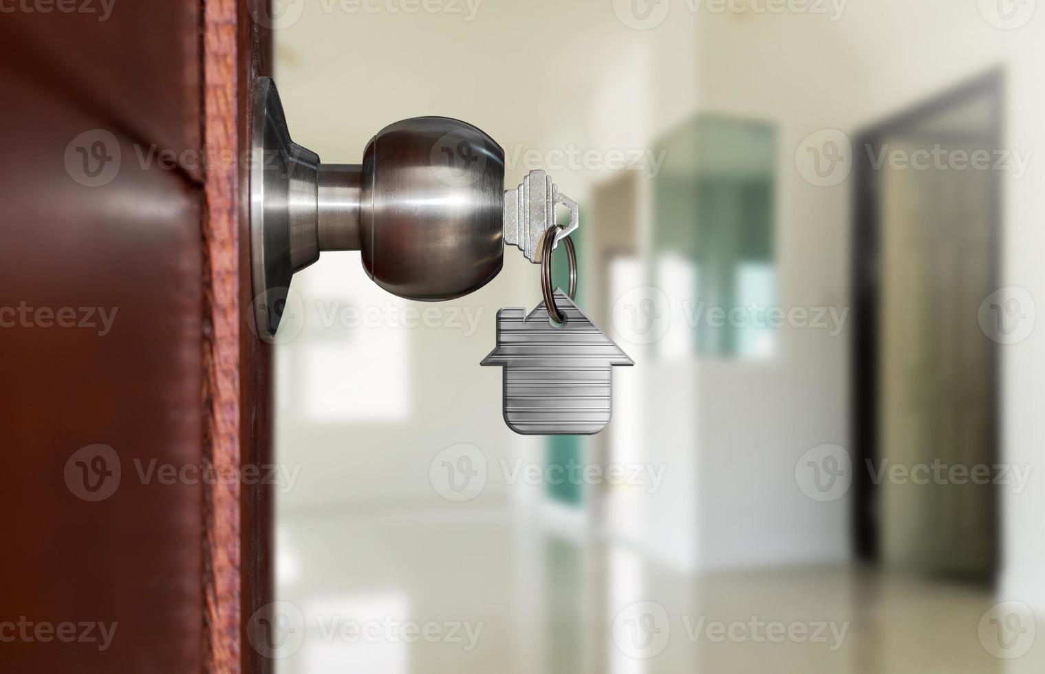 Open door with keys, House key in keyhole with small house photo