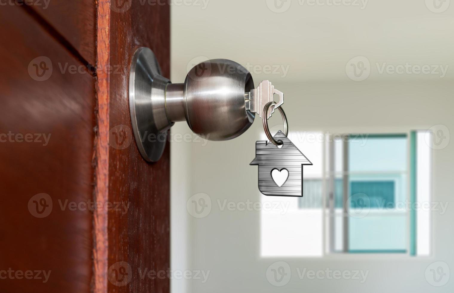 Open door with keys, House key in keyhole with small house photo