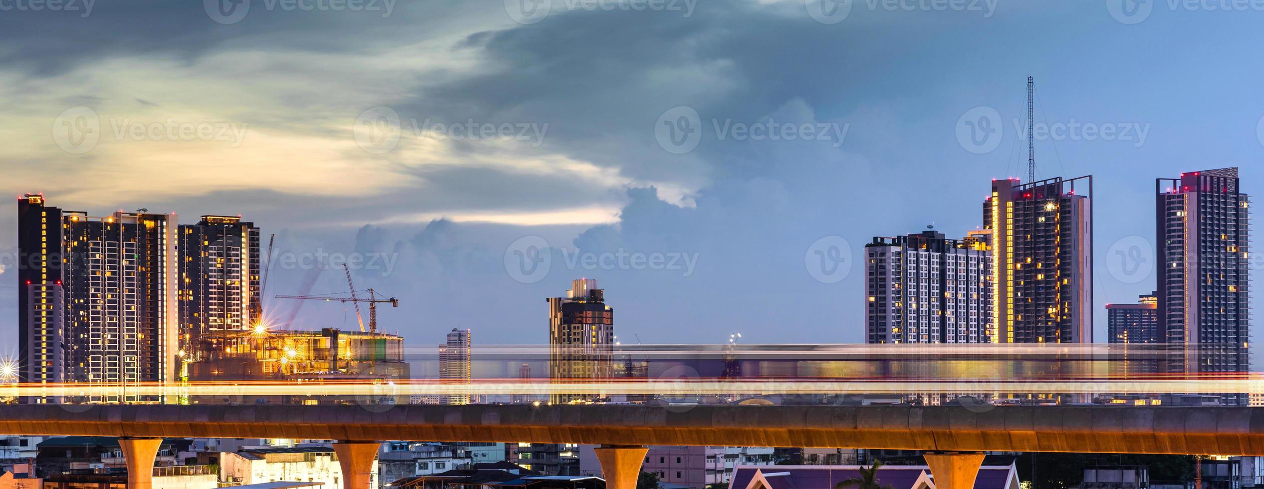 Light line of the Skytrain in city downtown with blue sky and clouds at Bangkok, Thailand photo