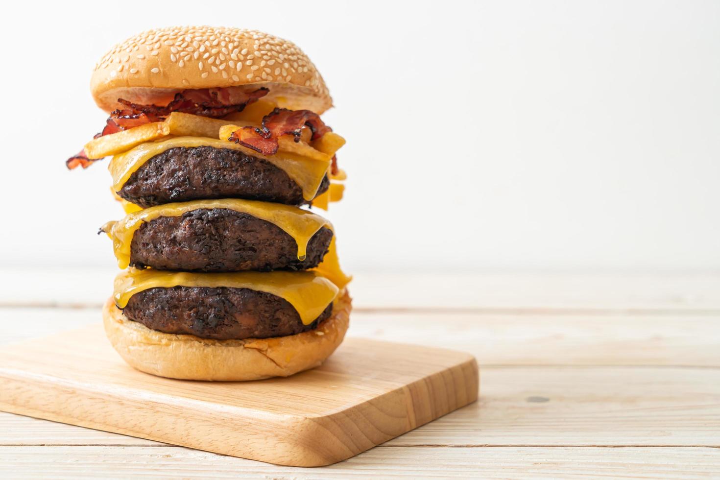 hamburguesas de hamburguesa o de ternera con queso, tocino y papas fritas: estilo de comida poco saludable foto